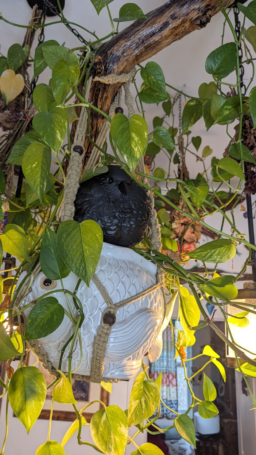 Raven figurine staged in a planter; styling props not included