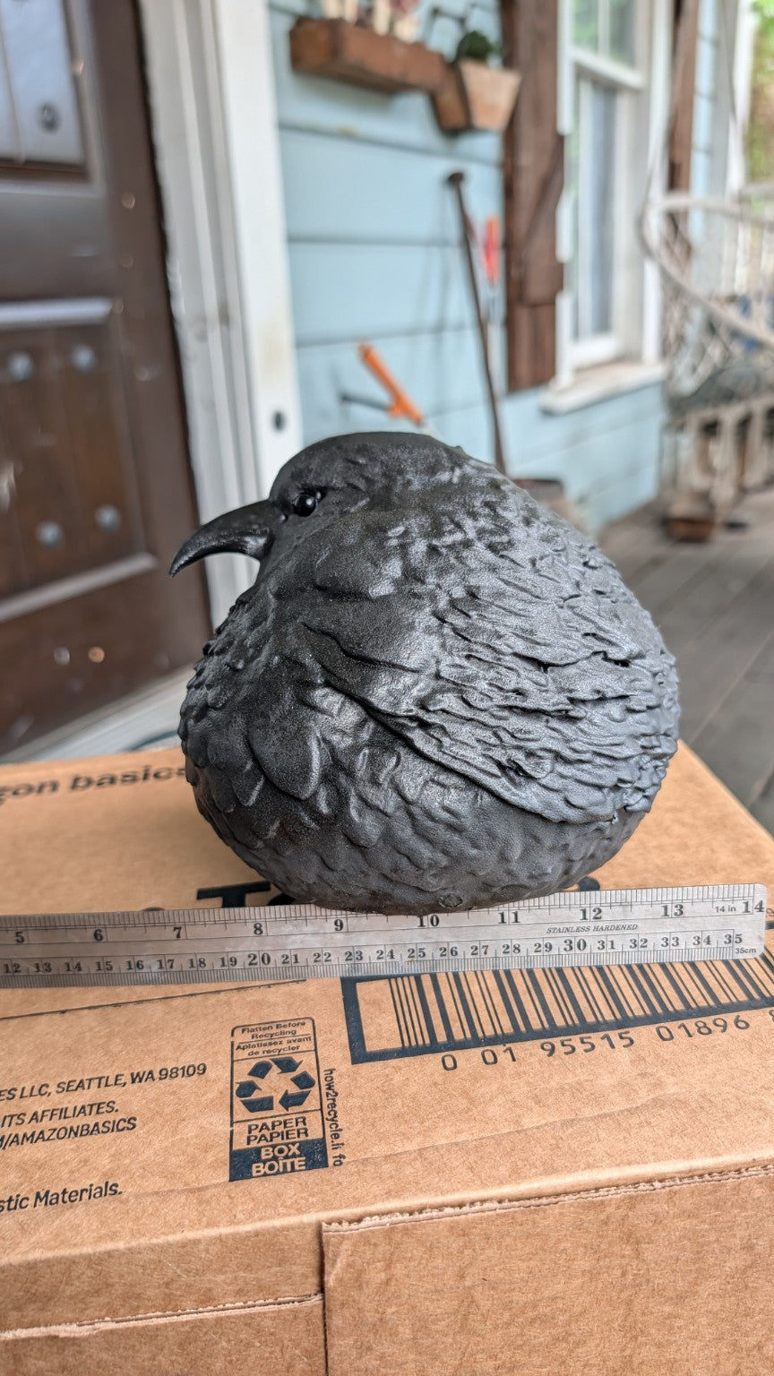 Alternate angle showing the raven's folded wing and sculpted feathers