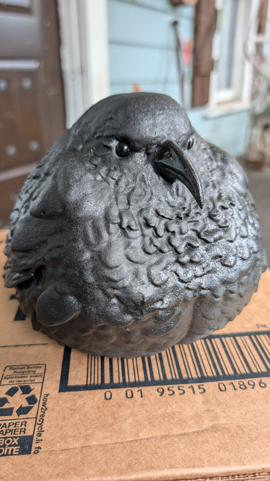 Front three-quarter view of Edgar Allan Dough, a charcoal fat raven figurine with glass eyes