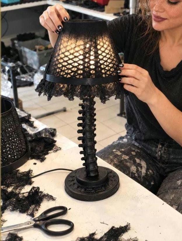 Black spine desk lamp and lace shade in a styled workshop scene