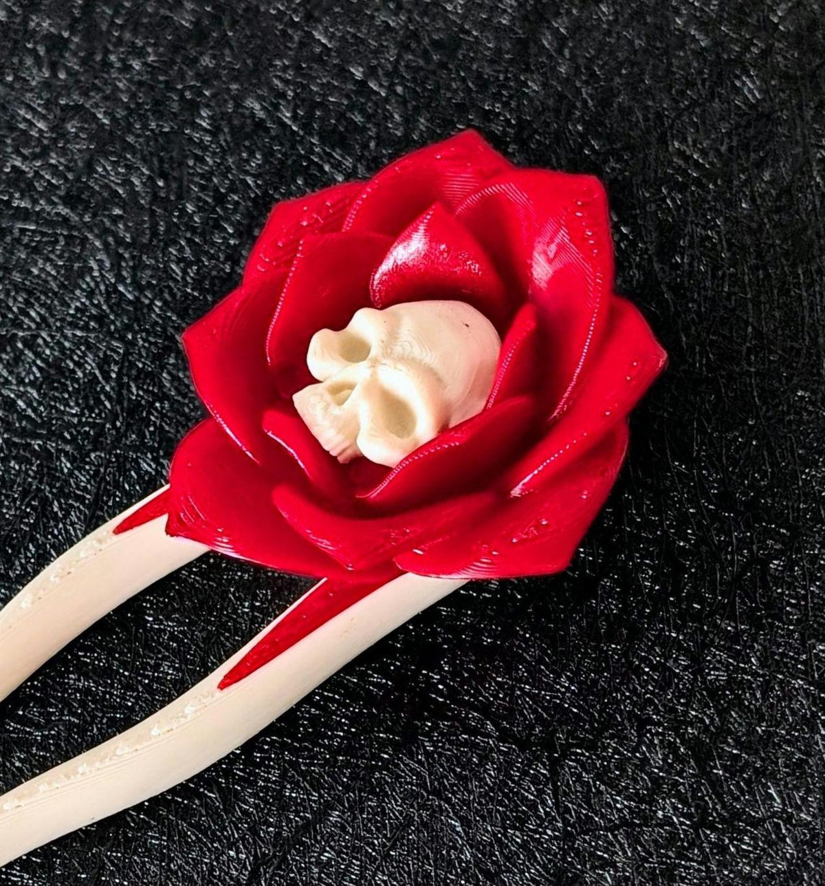 Close-up of the Death Blossom skull and red rose hair pin