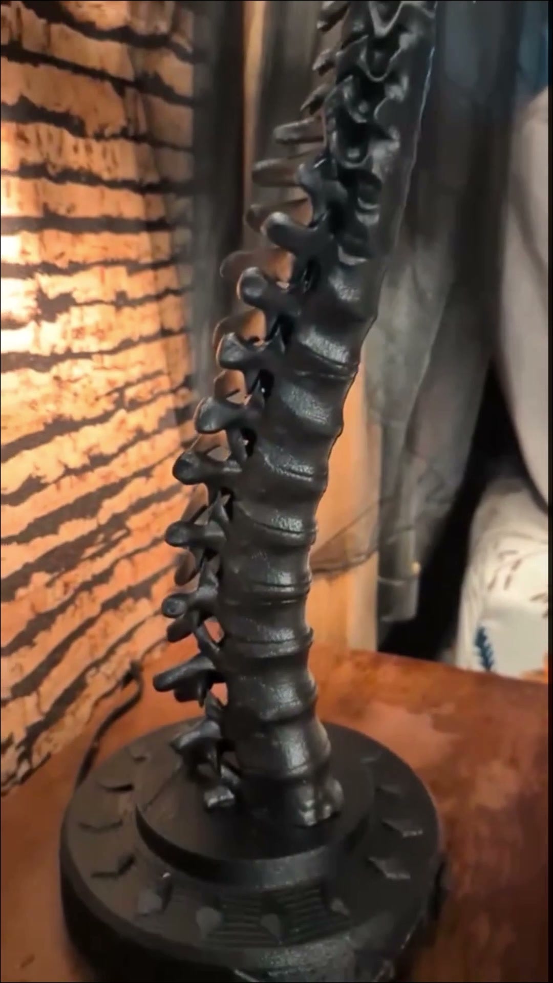 Real photo: close-up of the matte black sculpted spine and base